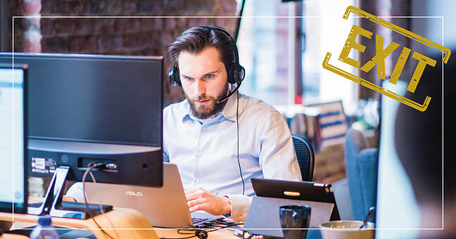 Mann mit Headset hinter Laptop
