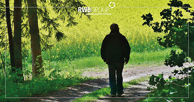 Wanderer mit Blick auf ein Rapsfeld