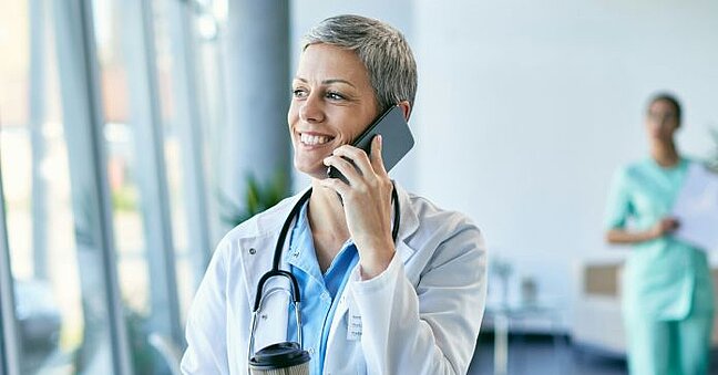 Frau im weissen Kittel am Telefon