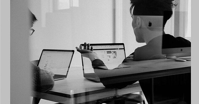 Mitarbeiter sitzend am Laptop-Bildschirm