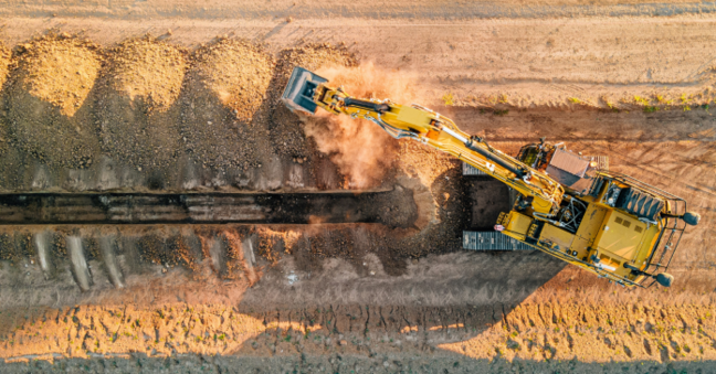 Bagger beim ausgraben eines Sandgeländes